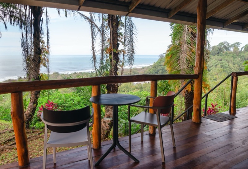 Covered wooden deck overlooking the jungle and ocean at Hotel Buenos Aires